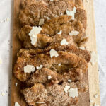 Chicken cutlets on a wooden cutting board.