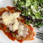 chicken parm served with a Caesar salad